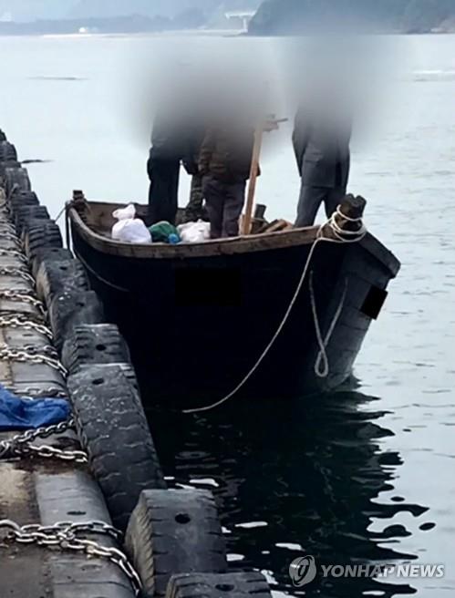 지난 15일 북한 선원 4명이 탄 어선이 연안에서 조업 중인 어민의 신고로 발견됐다는 정부 당국의 발표와 달리 삼척항에 정박했다고 KBS가 18일 보도했다. 사진은 북한 어선이 삼척항 내에 정박한 뒤 우리 주민과 대화하는 모습.  / 연합뉴스