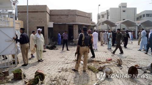 파키스탄 치안 병력이 21일 데라 이스마일 칸의 자살폭탄테러 현장을 수습하고 있다. [EPA=연합뉴스]