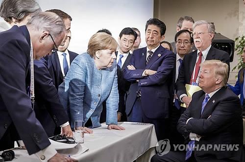 캐나다 퀘벡주 샤를부아에서 지난해 6월 9일(현지시간) 열린 주요 7개국(G7) 정상회의에서 도널드 트럼프 미국 대통령(오른쪽)이 팔짱을 낀 채 의자에 앉아 있고 앙겔라 메르켈 독일 총리(가운데 왼쪽)가 두 손으로 테이블을 누르며 트럼프 대통령을 내려다보고 있다. [AP=연합뉴스 자료사진]