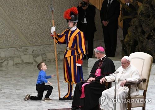 작년 11월 28일 바티칸에서 열린 수요 일반알현에서 한 6세 꼬마가 교황이 앉아 있는 단상 위로 올라와 장난을 치고 있다. [AFP=연합뉴스] 