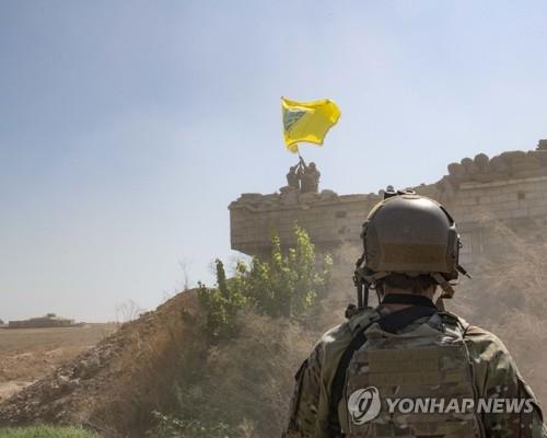 SDF 깃발을 흔드는 YPG 대원과 이를 바라보는 미군