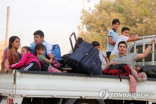터키군의 공격을 피해 시리아 국경도시 라스 알-아인을 탈출하는 가족