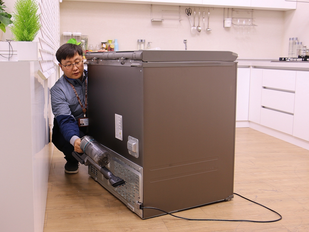 김치냉장고 기계실 먼지를 제거하는 삼성전자서비스 직원