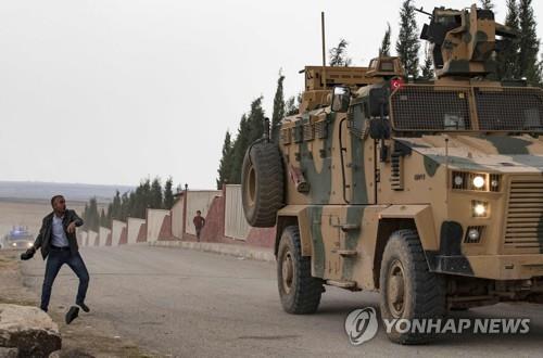 지난 4일 시리아 북부 하사카 주에서 터키군 차량에 신발을 던지는 쿠르드족 남성