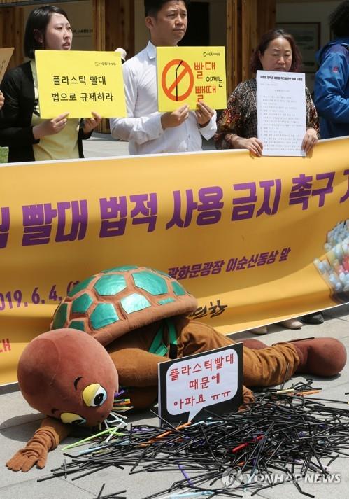 6월 4일 서울 광화문광장에서 열린 '일회용 플라스틱 빨대 법적 사용 금지 촉구' 기자회견에서 바다거북이 빨대 때문에 고통스러워하는 퍼포먼스가 펼쳐지고 있다. [연합뉴스 자료사진]