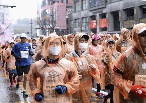 (구마모토 교도=연합뉴스) 지난 16일 일본 구마모토시에서 열린 마라톤대회 참가자들이 마스크를 쓰고 달리고 있다. 