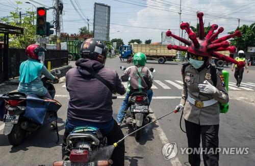 코로나 모자 쓰고 방역 활동하는 인도네시아 경찰