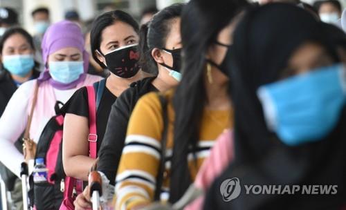 지난 5월 28일(현지시간) 필리핀 수도 마닐라의 국제공항에서 마스크를 쓴 채 줄을 선 필리핀 여성들.[AFP=연합뉴스]