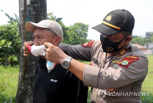 마스크 씌워주는 인도네시아 경찰
