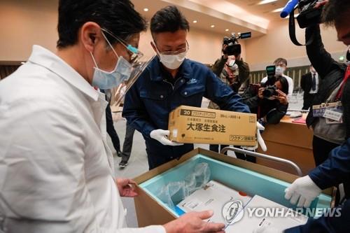 (도쿄 AFP=연합뉴스) 16일 도쿄의 한 병원 관계자가 화이자의 코로나19 백신을 수령한 뒤 온도를 확인하고 있다. sungok@yna.co.kr