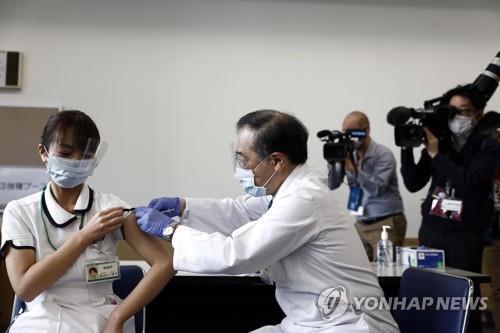 (도쿄 EPA=연합뉴스) 일본이 신종 코로나바이러스 감염증 백신 접종을 시작한 지난달 17일 도쿄에서 한 의료종사자(왼쪽)가 백신을 접종받고 있다. 