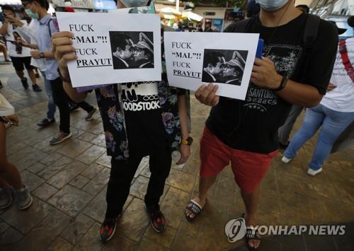 쿠데타 이후 태국에 사는 미얀마인들이 쁘라윳 태국 총리와 흘라잉 미얀마군 최고사령관을 나란히 담은 인쇄물을 들고 두 사람을 비판하는 시위를 벌이고 있다. 2021.2.28[EPA=연합뉴스]