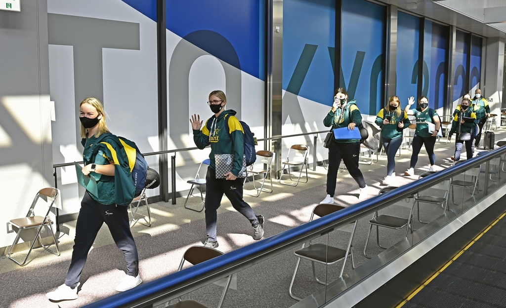 (나리타공항 교도=연합뉴스) 소프트볼 여자 호주 대표팀 선수와 관계자 등 약 30명이 1일 오전 나리타(成田)공항에 도착한 뒤 취재진에 손을 흔들어 인사하고 있다. 작년 3월 코로나19의 세계적 유행으로 도쿄올림픽이 1년 연기된 뒤 본대회 참가를 위해 일본에 들어온 외국선수단은 소프트볼 여자 호주 대표팀이 처음이다.