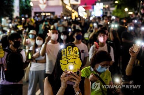 톈안먼 민주화시위 32주년을 맞은 4일 저녁 홍콩 코즈웨이베이에서 시민들이 일제히 휴대전화 손전등을 켜며 희생자들을 추모했다.[AFP=연합뉴스]