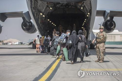 23일 카불공항에서 피난민이 미군 수송기에 타는 모습