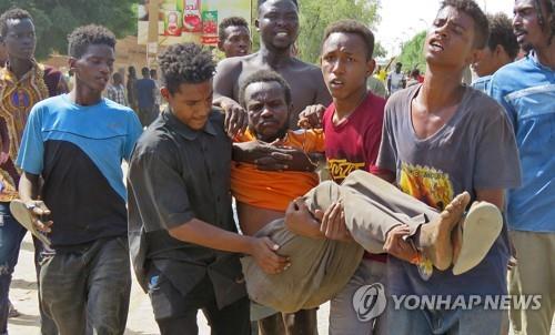 반쿠데타 시위 도중 부상한 남성을 옮기는 하르툼 시민들.