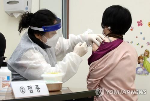Una ciudadana recibe una vacuna contra el COVID-19 de AstraZeneca, en un centro de salud pública, en Incheon, a 50 kilómetros al oeste de Seúl, el 26 de febrero de 2021, cuando el país inició su campaña de vacunación a nivel nacional, a las 9:00 a.m.
