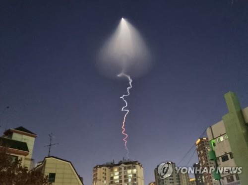 En la foto, tomada desde el barrio de Oksu, en Seúl, se observa una luz ascendente que deja una estela de humo, el 30 de diciembre de 2022. El fenómeno se observó desde diferentes puntos del país, y posteriormente, a las 6:50 p.m., el Ministerio de Defensa anunció que un vuelo de prueba de un vehículo de lanzamiento espacial con combustible sólido había sido realizado con éxito.