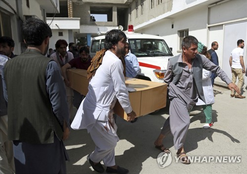 11일 아프가니스탄 카불에서 주민들이 자폭테러 희생자의 시신을 옮기고 있다.[AP=연합뉴스]