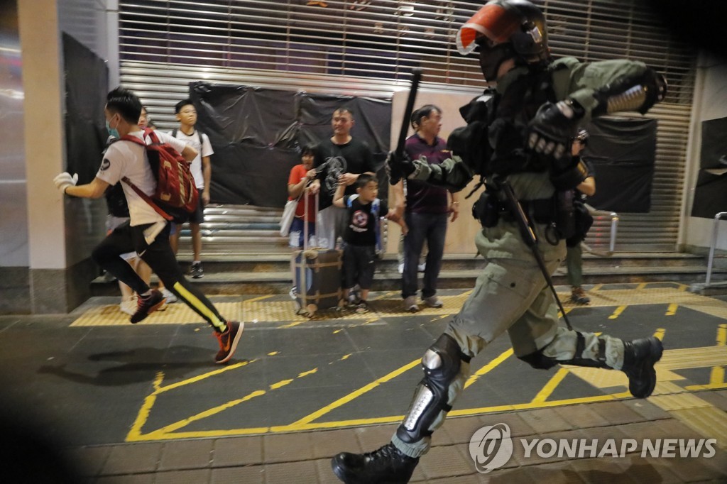 경찰이 지난 13일 시위 참가자를 쫓고 있다. [AP=연합뉴스]
