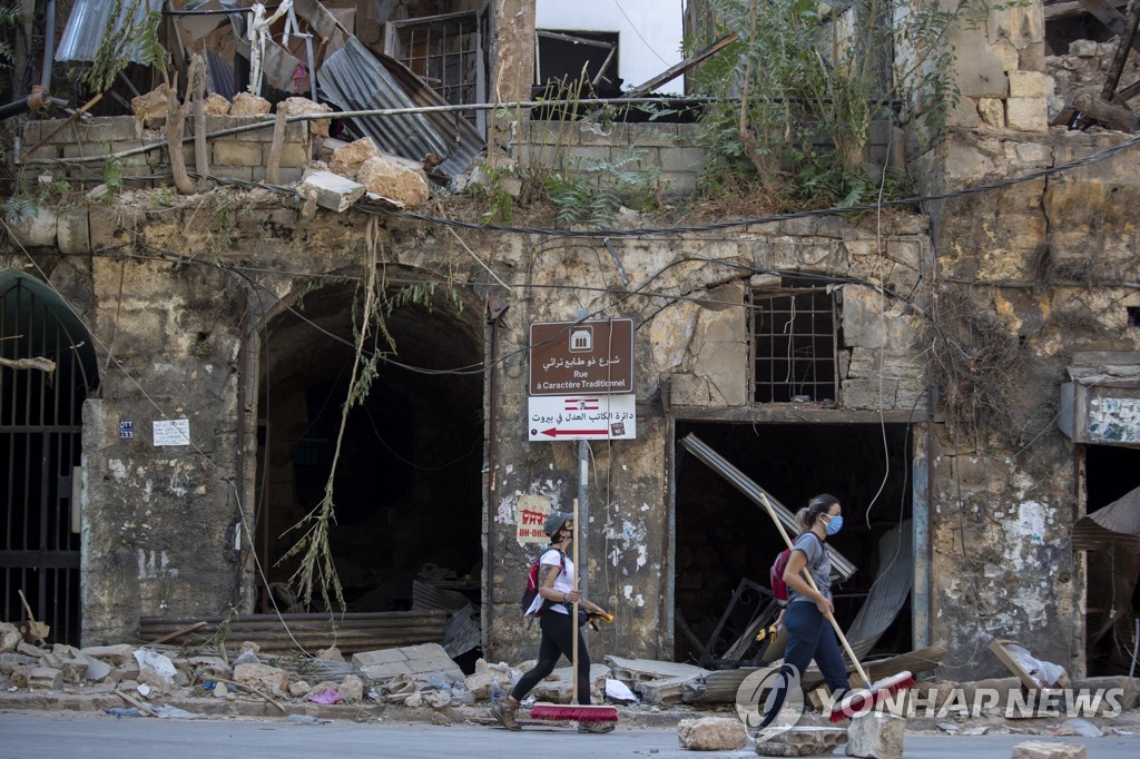 지난 8일 레바논 베이루트의 한 유서깊은 건물이 파손된 현장을 자원봉사를 나온 시민들이 지나가고 있다. [AP=연합뉴스 자료사진] 