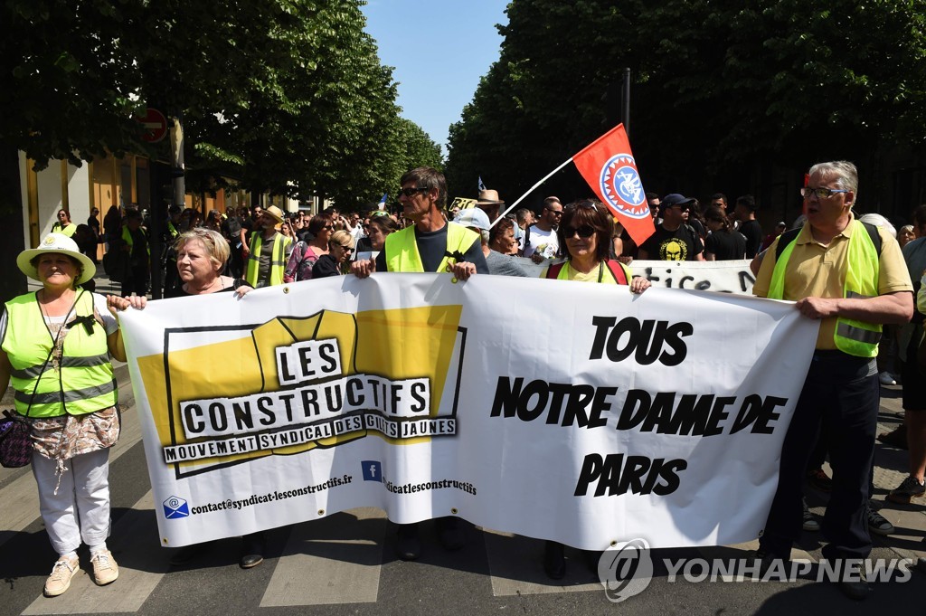 20일(현지시간) 프랑스 보르도에서 '노란 조끼' 시위대가 '우리 모두 노트르담 드 파리다'라는 현수막을 들고 행진하고 있다 [AFP=연합뉴스]