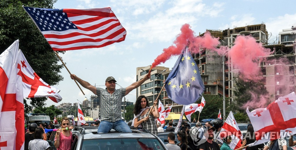 조지아 국기와 미국 국기, EU 깃발 흔드는 트빌리시 거리의 시위대