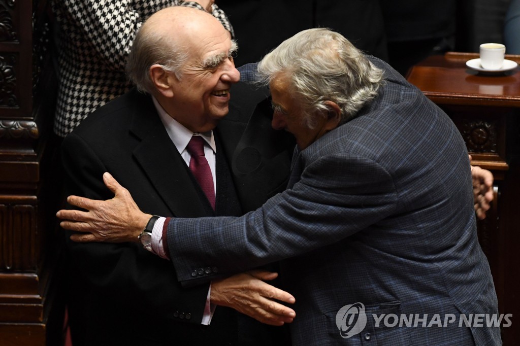 20일(현지시간) 포옹하는 우루과이 두 전직 대통령 상기네티(왼쪽)와 무히카