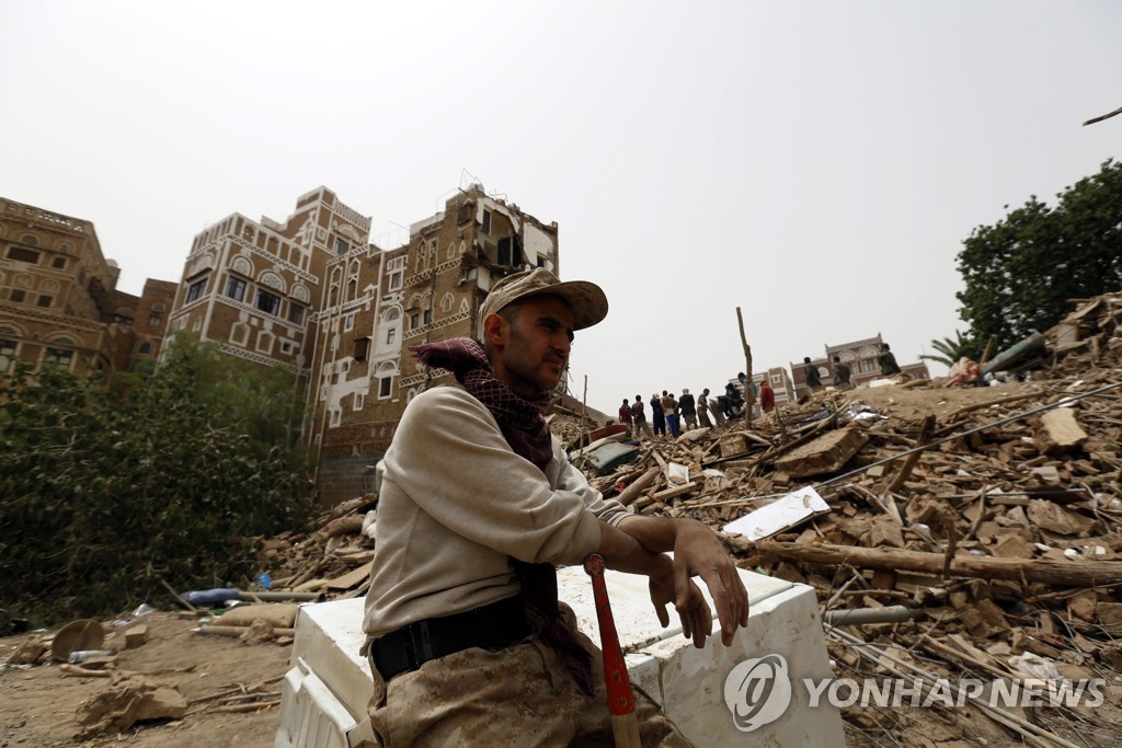 2015년 6월 한 예멘인이 사우디아라비아 주도 아랍연합군 공습에 부서진 건물 앞에 앉아 있다. [EPA=연합뉴스 자료사진]