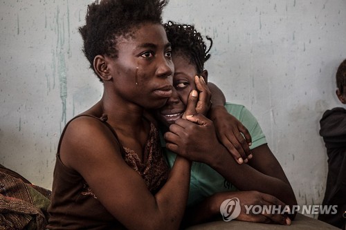 리비아 난민 수용소에서 눈물 흘리는 두 나이지리아 여성