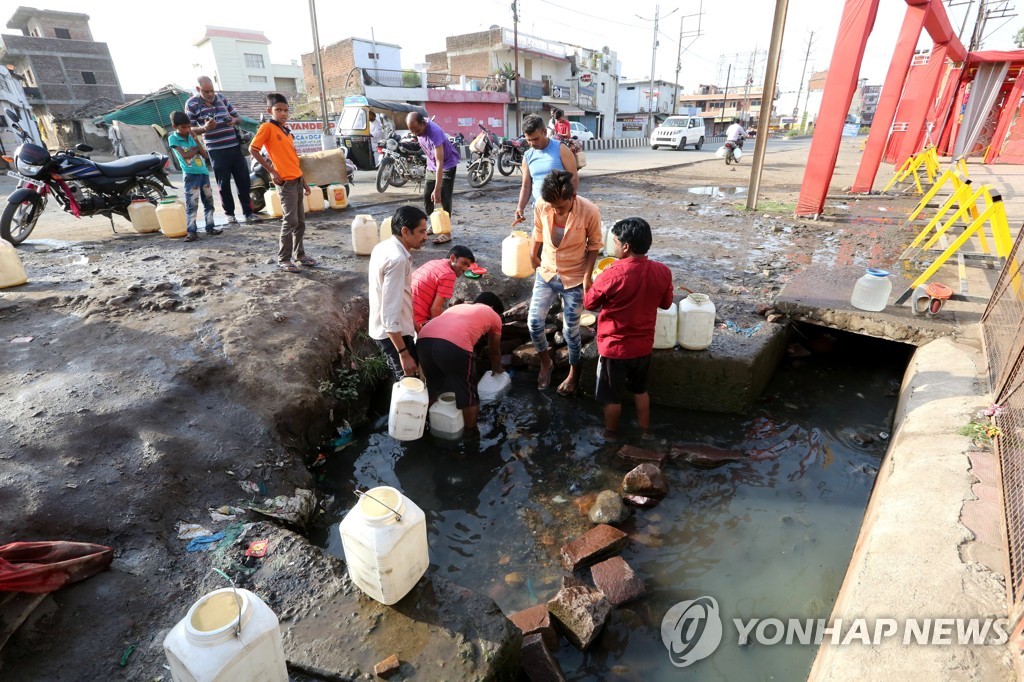 인도의 공공 급수관에서 물을 떠 가는 주민들