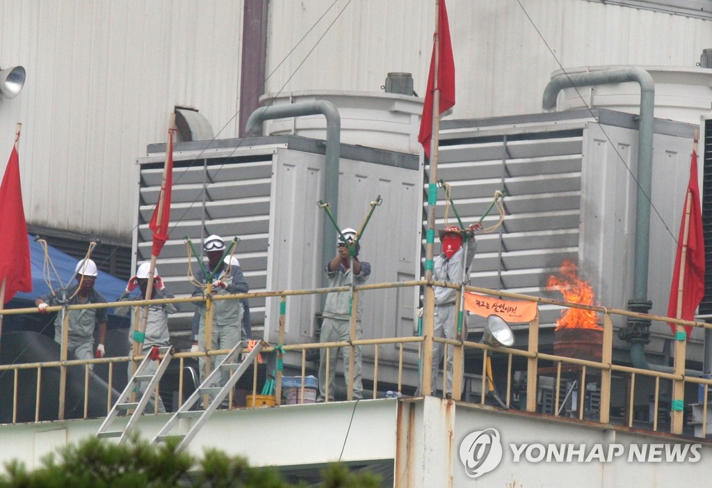 지난 2009년 7월 20일 쌍용차 평택공장 도장공장에서 노조원들이 새총을 쏘고 있다. << 연합뉴스 DB >>