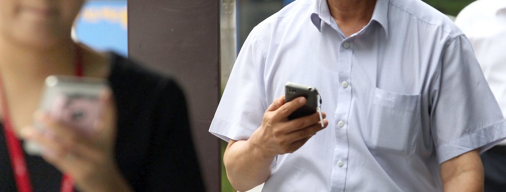 시민들이 거리를 걸어가며 스마트폰을 보고 있다. <<연합뉴스DB>>
