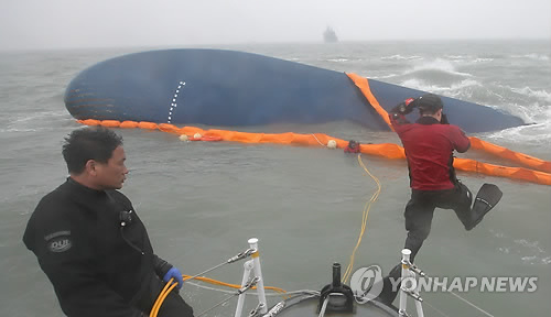 17일 오후 여객선 '세월호'가 침몰한 전남 진도군 조도면 병풍도 북쪽 3km 앞 해상에서 해경과 중앙119, 해상구난 민간업체 수중다이버들이 선내 진입을 위한 탐색선 설치 작업을 하고 있다.