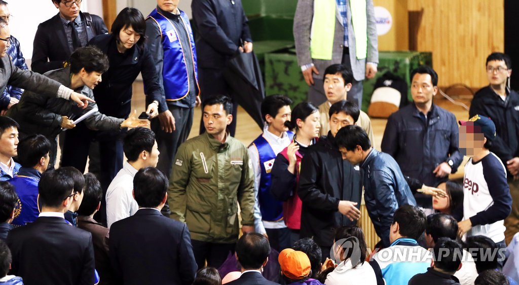 박근혜 대통령이 17일 오후 여객선 침몰 실종자 가족들이 모여 있는 진도실내체육관을 찾아 실종자 가족이 건내는 휴대전화를 받고 있다. 