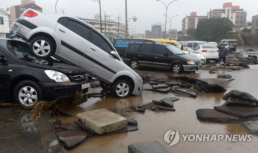불어난 물에 휩쓸려 뒤엉킨 차량[연합뉴스 자료사진]