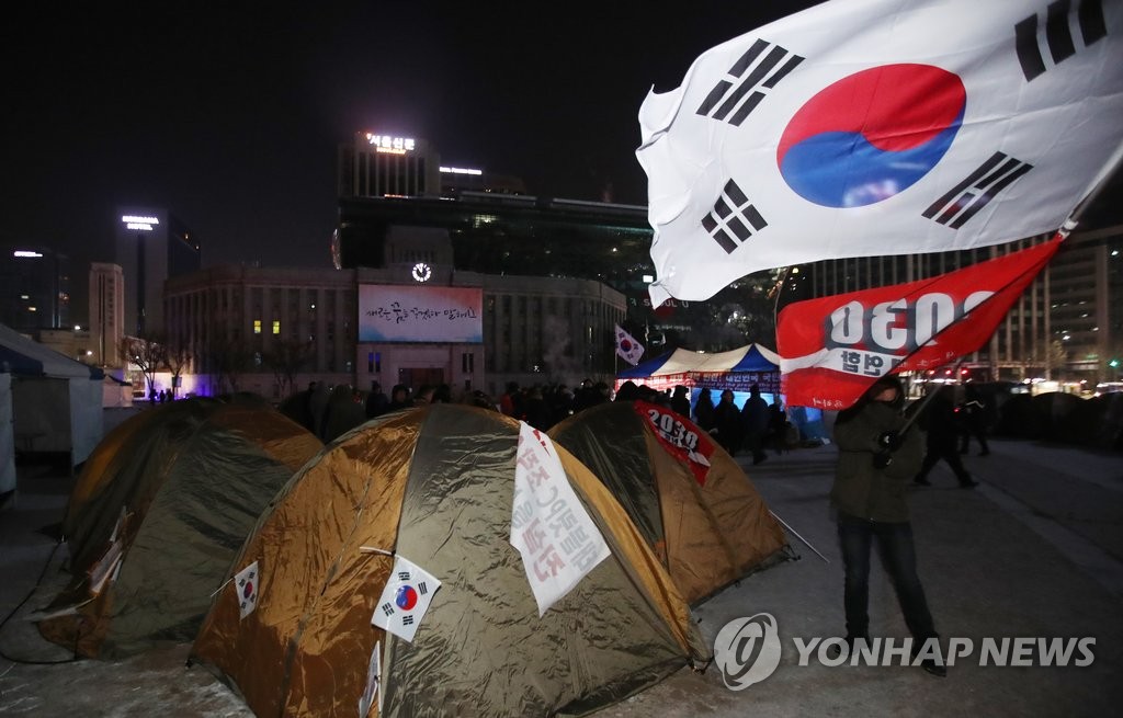서울광장 '노숙텐트' 앞에서 태극기 흔드는 보수단체