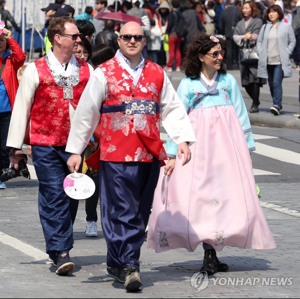 韓服（韓国伝統衣装）を着てソウル市内の歩行者天国を歩く外国人観光客＝（聯合ニュース）