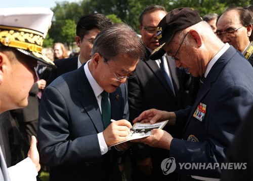 참전용사에게 사인 해주는 문 대통령
