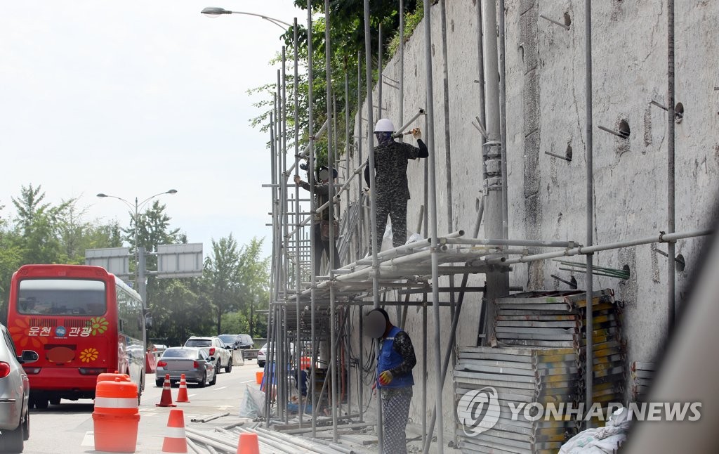 2018년 8월 19일 서울 남산1호터널 진입부 도로변에서 작업자들이 도로 외벽 보강공사를 하고 있다. [연합뉴스 자료사진]