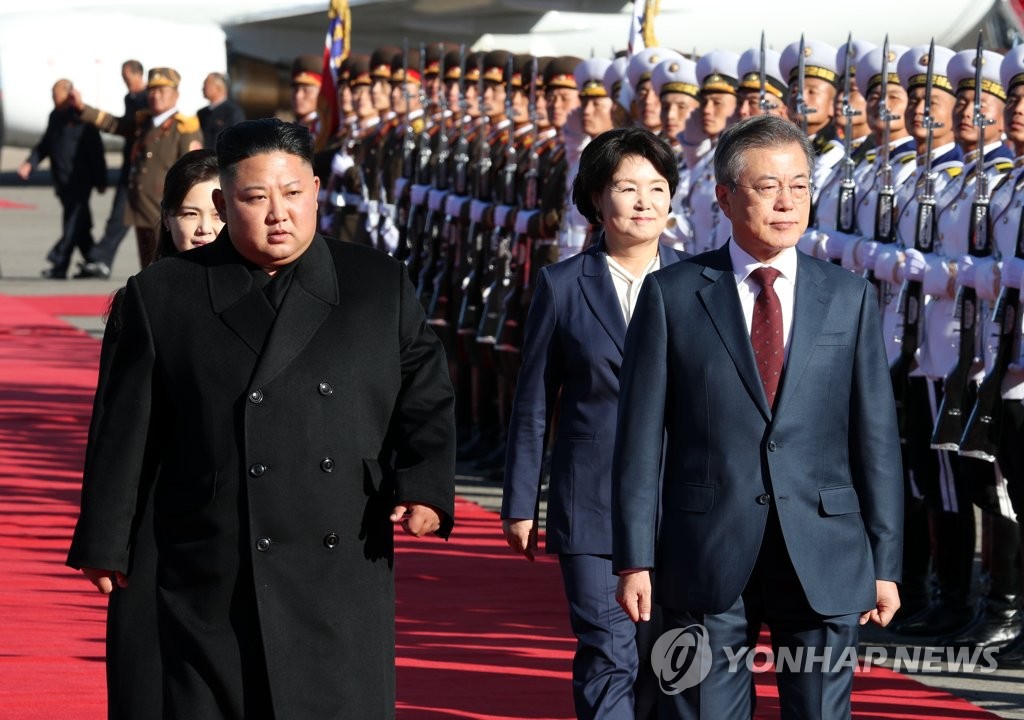 South Korean President Moon Jae-in (front, R) and North Korean leader Kim Jong-un (front, L) review an honor guard at Samjiyon Airport on Sept. 20, 2018, after arriving for an excursion to Mount Paekdu. The two leaders and their wives traveled to the tallest mountain on the Korean Peninsula, also accessible from the Chinese border, from the rarely opened North Korean side. Moon returned home later in the day, ending his three-day visit to North Korea. (Pool photo) (Yonhap)