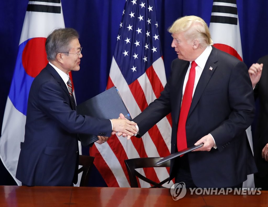 South Korean President Moon Jae-in (L) and U.S. President Donald Trump shake hands after signing the official document on the revised free trade agreement between the two allies at Lotte New York Palace in New York on Sept. 24, 2018. (Yonhap)