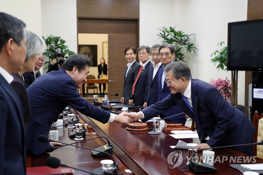 South Korean President Moon Jae-in (R) shakes hands with Prime Minister Lee Nak-yon at the start of a National Security Council Meeting held at the presidential office Cheong Wa Dae in Seoul on March 4, 2019. (Yonhap)