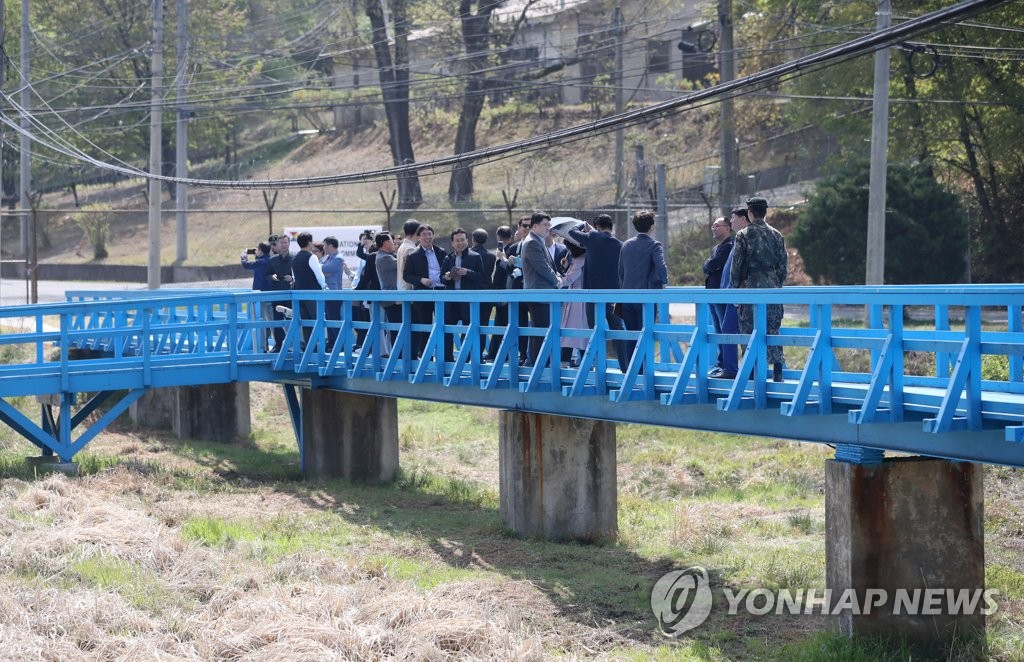 Des visiteurs se tiennent sur une passerelle dans la Zone commune de sécurité (JSA) du village frontalier de Panmunjom, le 1er mai 2019, alors que les visites à la JSA ont repris après une suspension temporaire. La passerelle est devenue célèbre après que le président Moon Jae-in et le dirigeant nord-coréen Kim Jong-un s'y sont promenés lors de leur premier sommet en avril de l'année précédente.