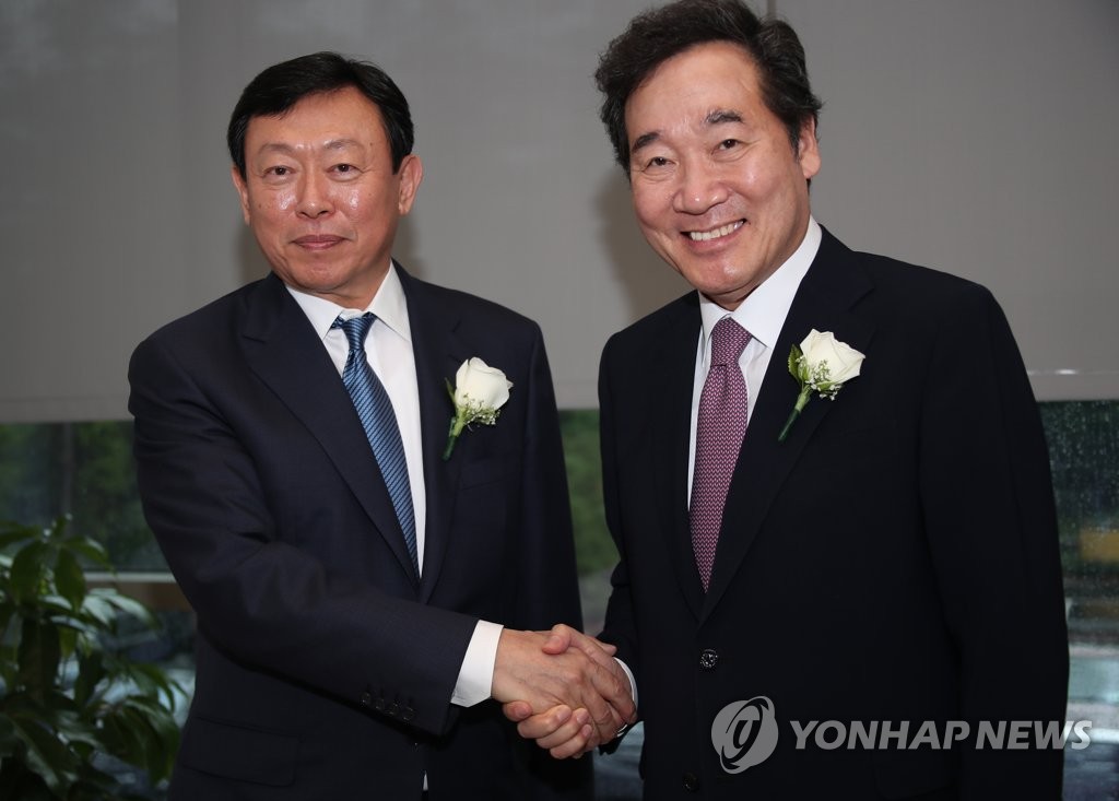 Prime Minister Lee Nak-yon (R) and Shin Dong-bin, chief of South Korea's retail giant Lotte Group, shake hands ahead of a ceremony to mark the completion of the construction of a factory of Lotte Chemical in Louisiana, the United States, on May 10, 2019. (Yonhap)