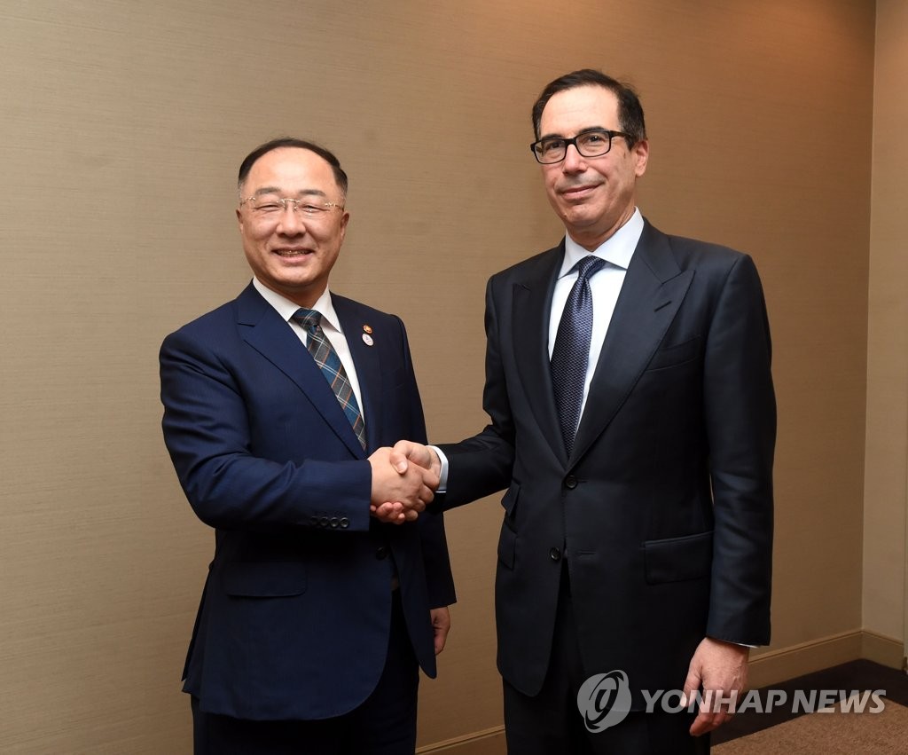 Hong Nam-ki (L), the minister of economy and finance, shakes hands with U.S. Treasury Secretary Steven Mnuchin at a hotel on the sidelines of an annual meeting of the Group of 20 finance ministers in Japan on June 9, 2019, in this photo provided by the ministry. (PHOTO NOT FOR SALE) (Yonhap)