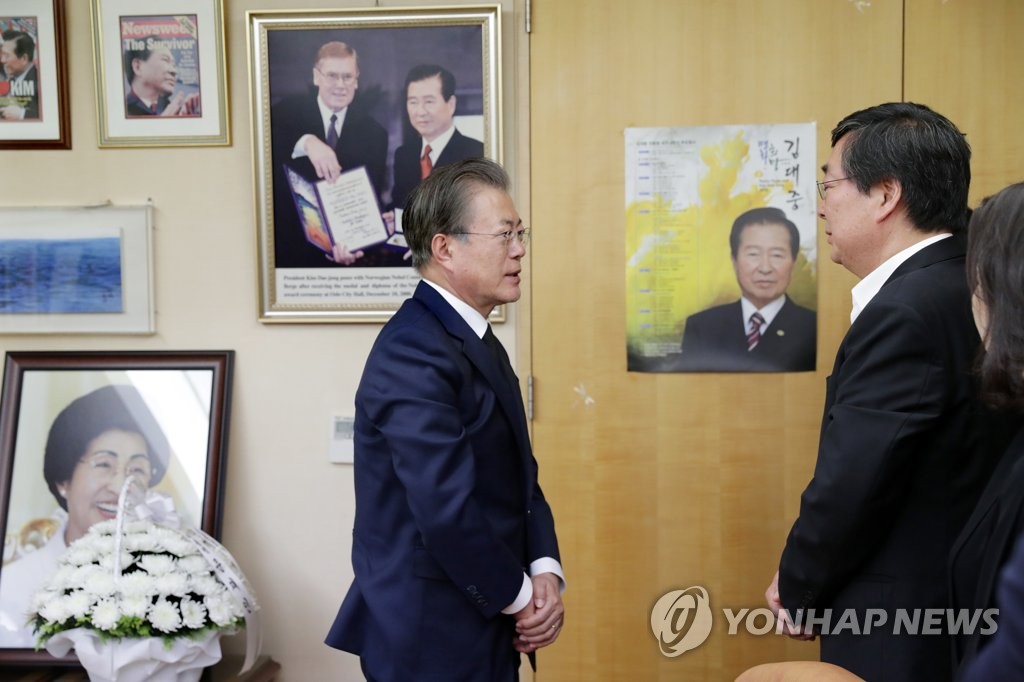 Le président Moon Jae-in parle à Kim Hong-eop, le second fils de l'ancienne Première dame Lee Hee-ho, au domicile de cette dernière ce dimanche 16 juin 2019 à Séoul. 