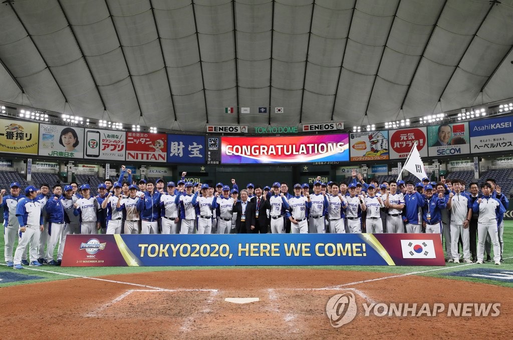 In this file photo from Nov. 15, 2019, South Korean players and coaches pose behind the banner showing their qualification for the 2020 Olympic baseball tournament after defeating Mexico 7-3 in the Super Round game at the World Baseball Softball Confederation (WBSC) Premier12 at Tokyo Dome in Tokyo. (Yonhap)