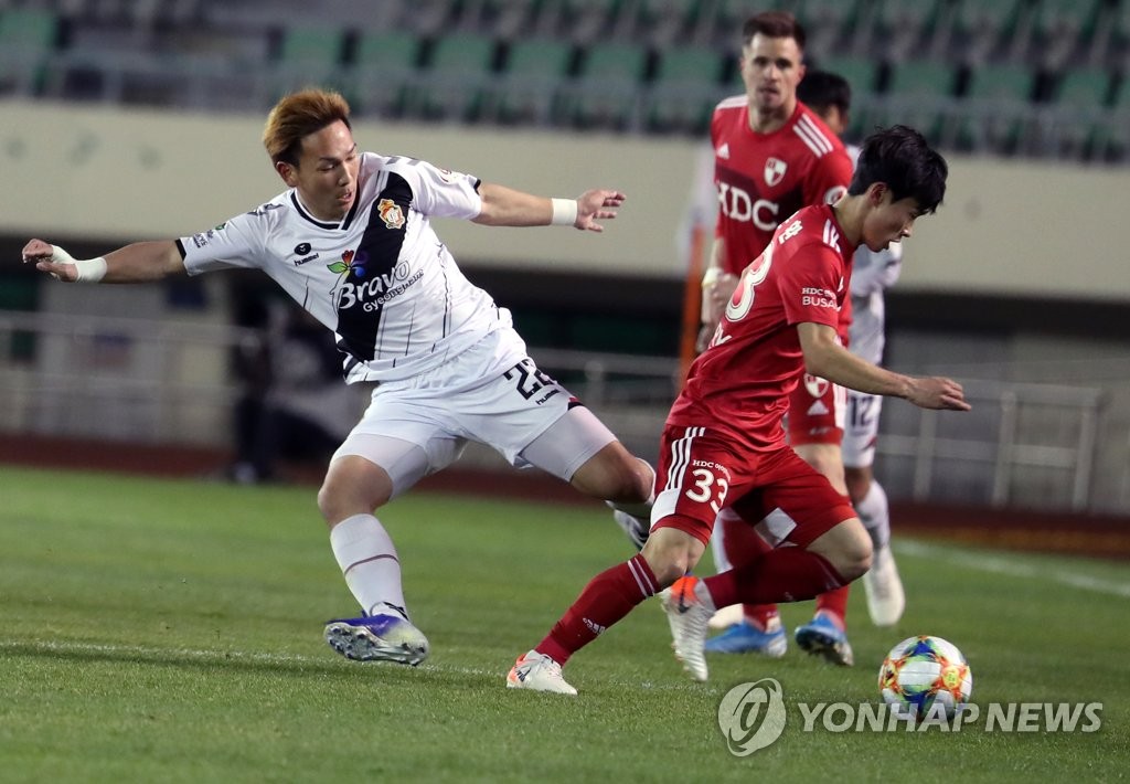 Kim Moon-hwan of (R) dribbles the ball past Takahiro Kunimoto of Gyeongnam FC during the clubs' K League promotion-relegation playoff at Busan Gudeok Stadium in Busan, 450 kilometers southeast of Seoul, on Dec. 5, 2019. (Yonhap)