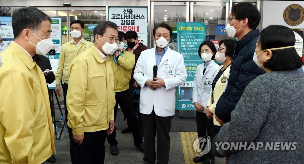 President Moon Jae-in (front, 2nd from L) talks with workers at Daegu Medical Center on Feb. 25, 2020. (Yonhap)